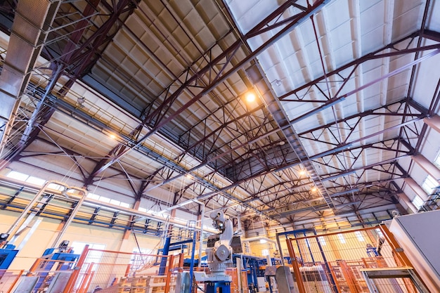 Interno dell'officina di fabbrica e macchine sul processo di produzione del fondo dell'industria del vetro