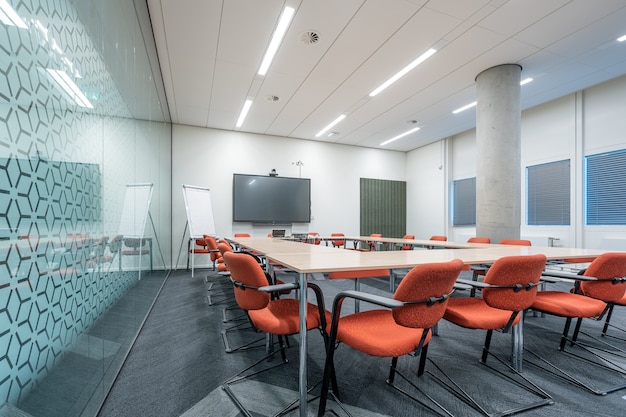 Interno della sala conferenze di un ufficio moderno con pareti bianche e un monitor