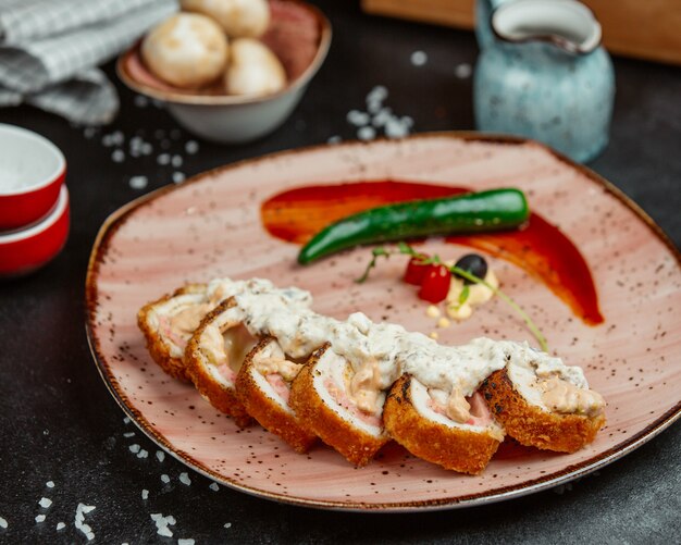 Involtini di filetto di pollo croccante con salsa di pomodoro e peperoncino verde.