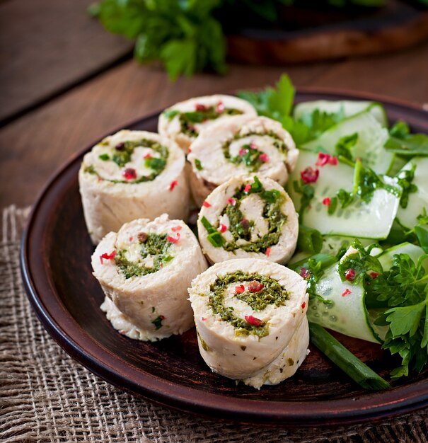 Involtini di pollo al vapore con verdure e insalata di verdure fresche su un piatto marrone