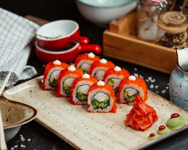 Involtini di sushi con caviale rosso in cima, zenzero e wasabi.