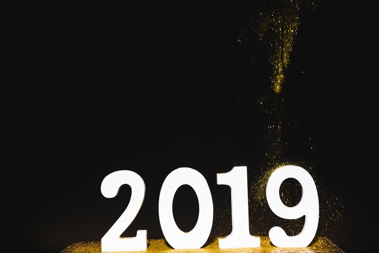 Foto gratuito iscrizione bianca 2019 con paillettes che cadono