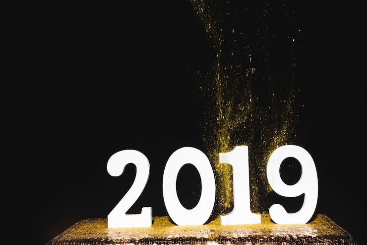 Foto gratuito iscrizione bianca 2019 con paillettes dorate sul tavolo