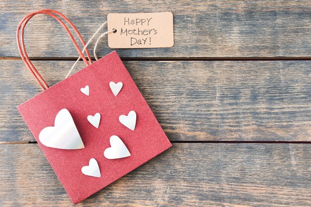 Iscrizione di Happy Mothers Day con sacchetto di carta e cuori