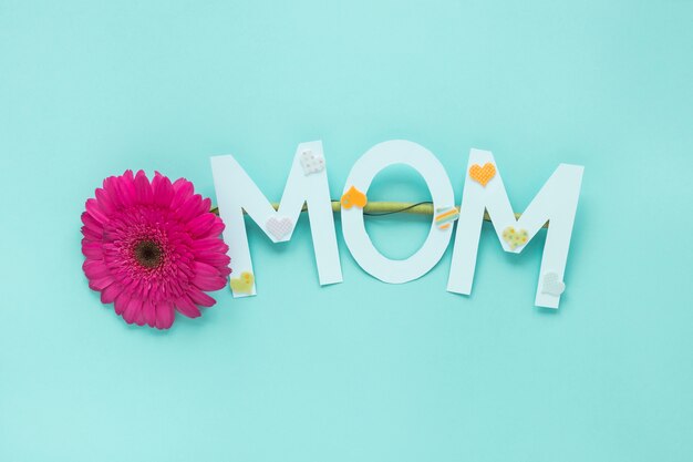 Iscrizione di mamma con fiore gerbera sul tavolo