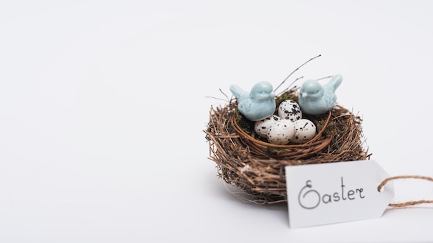 Iscrizione di Pasqua con uova di quaglia nel nido sul tavolo