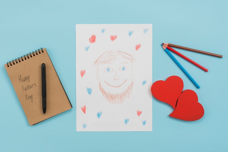 Foto gratuito iscrizione felice di giorno di padri in blocco note con il disegno dell'uomo