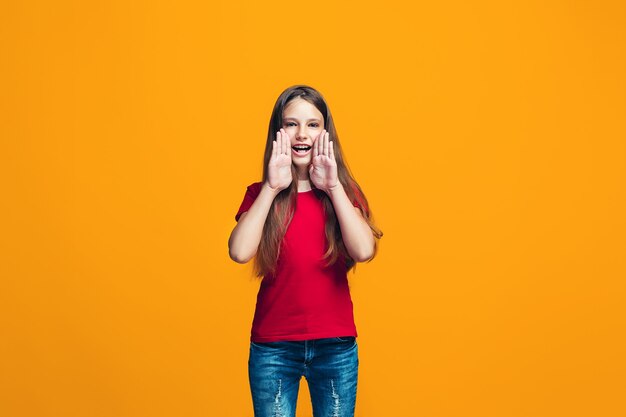 Isolato su giallo giovane ragazza adolescente casuale che grida allo studio