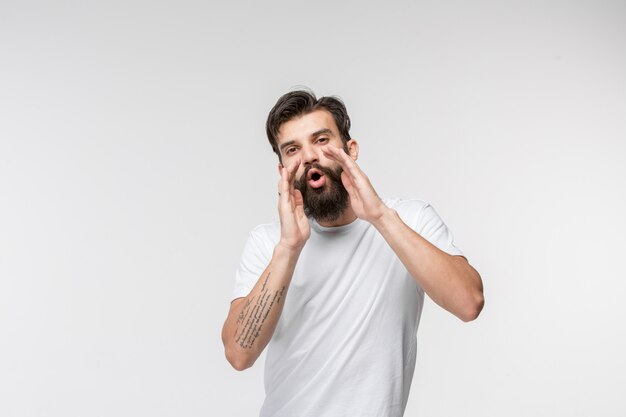 Isolato sul giovane uomo casuale rosa che grida allo studio