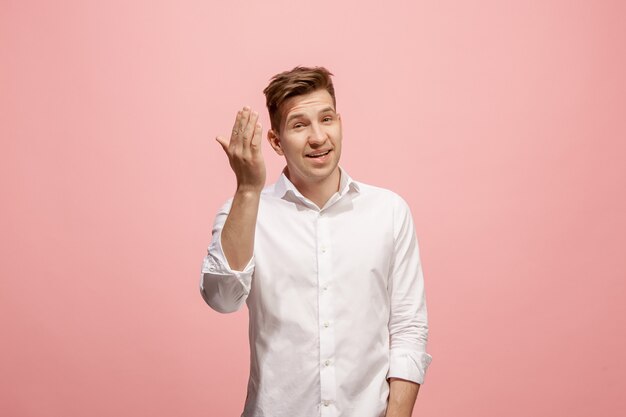 Isolato sul giovane uomo casuale rosa che grida allo studio