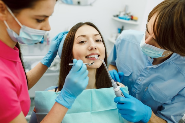 Ispezione dei denti della donna con l'aiuto di uno specchio.