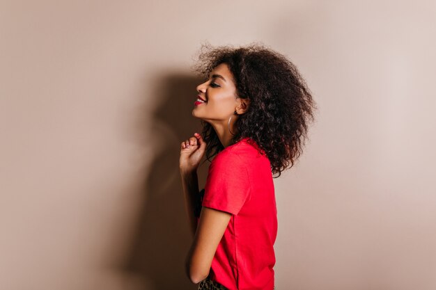 Ispirata donna dai capelli castani in abbigliamento casual che esprime emozioni sincere