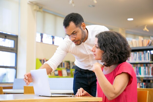 Istruttore che controlla il lavoro dello studente in biblioteca