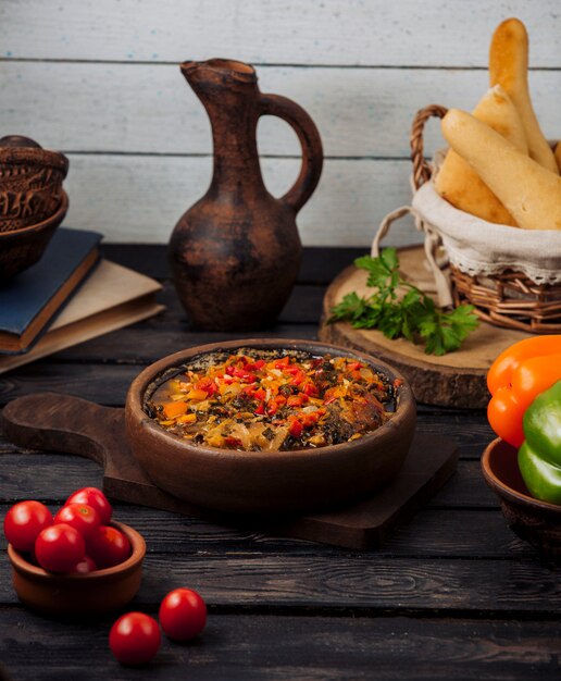 Kebab di agnello arrostito con cipolla, pomodoro e peperoni in padella di terracotta