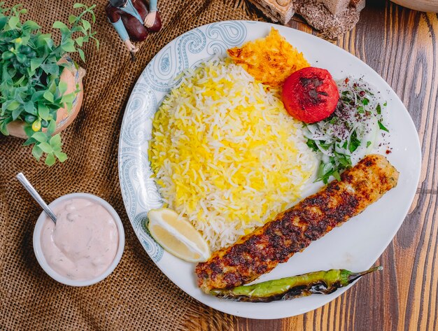 Kebab di lula di pollo vista dall'alto con verdure grigliate di riso e cipolle