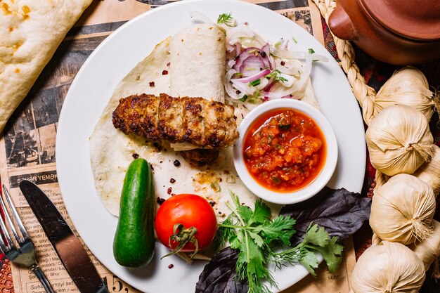 Kebab di lula di vista superiore in pane della pita con le verdure e la salsa