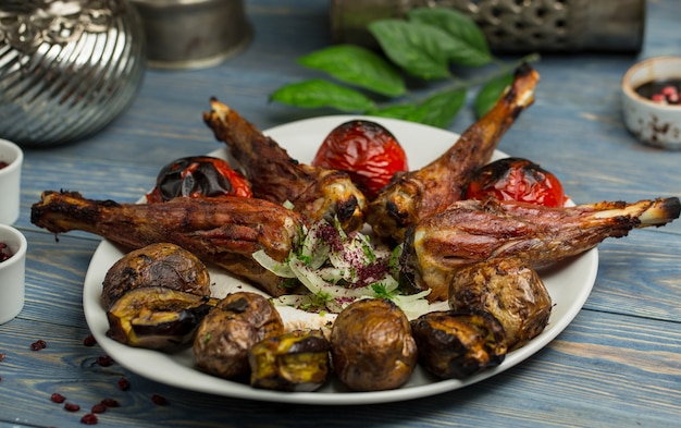 Kebab di pepita di pollo con patate grigliate e pomodori.