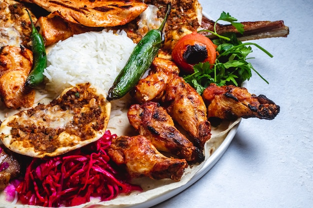 Kebab di pollo di vista laterale con il cavolo ed il riso marinati pomodoro caldo caldo del peperone verde sulla pita