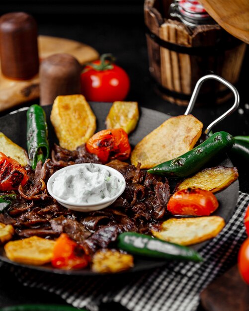 Kebab di saj di agnello cotto con pomodoro, patate e melanzane