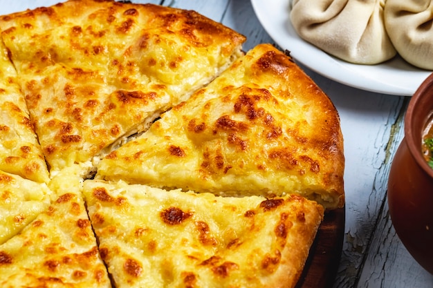 Khachapuri imeretian di vista laterale con formaggio sulla tavola