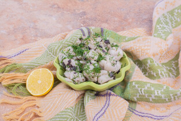 Khinkali caucasico crudo con erbe tritate in una ciotola.