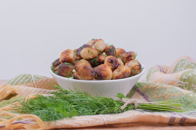 Khinkali caucasico fritto con erbe in una ciotola bianca