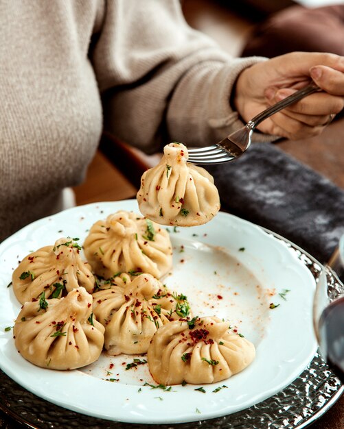 Khinkali georgiano tenuto da una forchetta