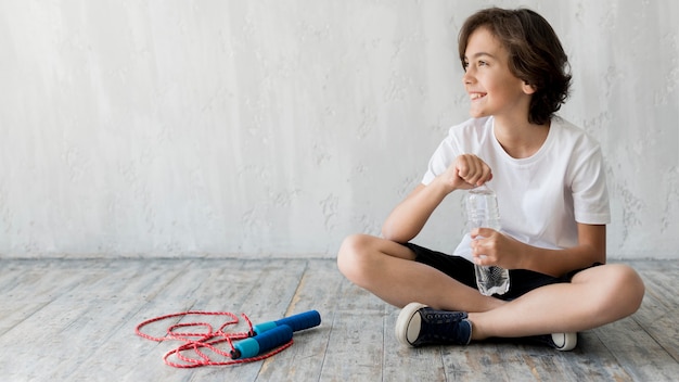 Kid sul pavimento accanto a saltare la corda