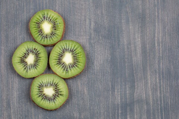 Kiwi e fette maturi su superficie di legno