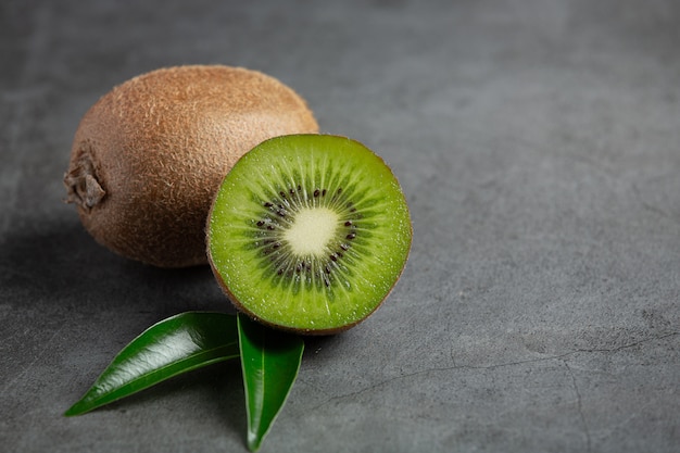 Kiwi fresco, tagliato a metà, messo sul pavimento scuro