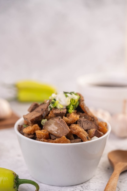 Kuay Jab in una tazza con polpette di carne di maiale e cracker di maiale.