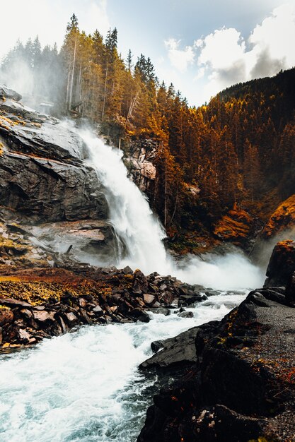 L'acqua cade sulla montagna rocciosa marrone durante il giorno