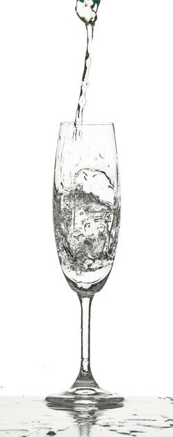 L'acqua che spruzza il vetro inro su sfondo bianco