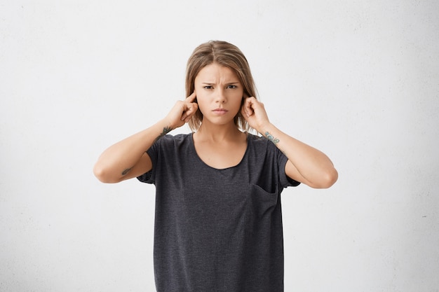 L'adolescente infelice e stressata che tappando le orecchie con le dita non vuole sentire rumori fastidiosi o ignorare situazioni o conflitti stressanti e spiacevoli.