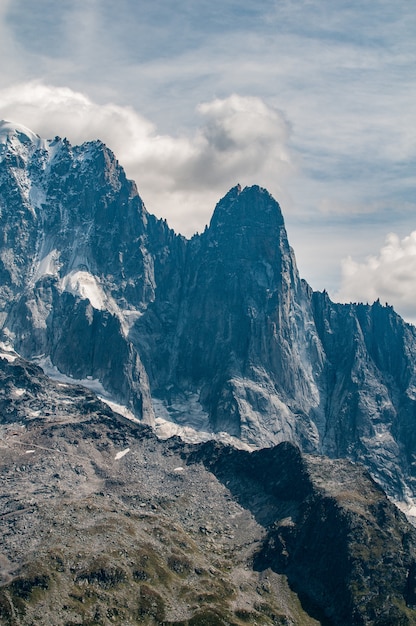 L'Aiguilles des Drus accanto all'Aiguille Verte sopra la valle di Chamonix con nuvole e cielo blu