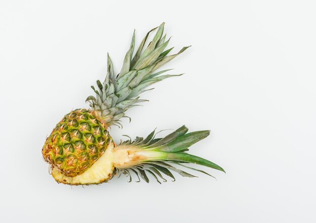 L'ananas succoso ha tagliato a metà su bianco. disteso.