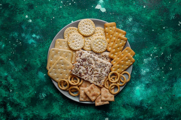 L'assortimento dei cracker del sale ha sparato dalla cima su variopinto con la copia. Mix di snack salati per feste