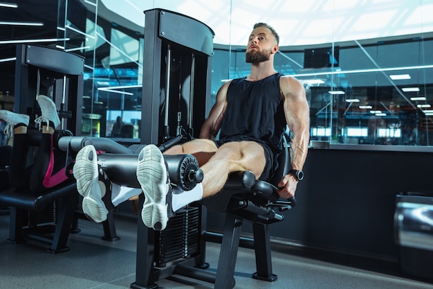 L'atleta maschio che si allena duramente in palestra. Fitness e concetto di vita sana.