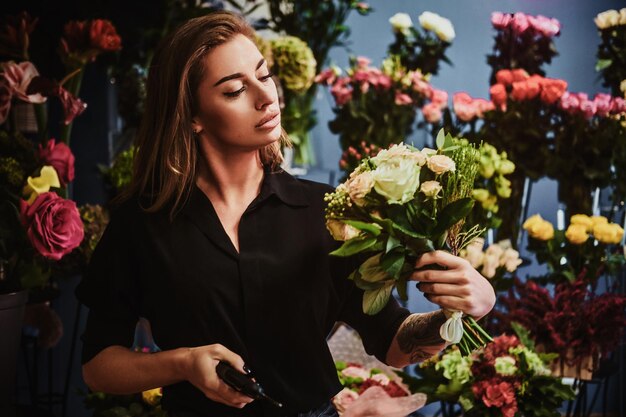 L'attraente proprietario di un negozio di fiori ha appena creato un bellissimo bouquet di rose bianche.