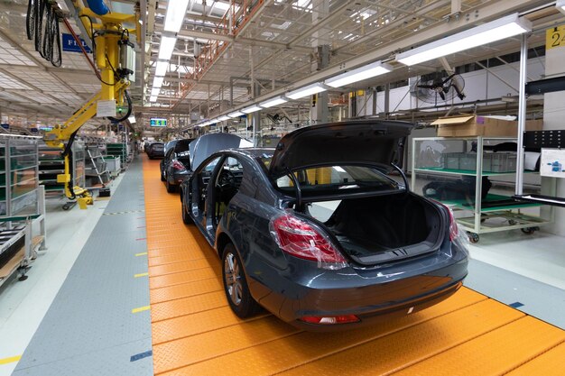 L'auto assemblata è sulla catena di montaggio L'attrezzatura robotica effettua l'assemblaggio dell'auto L'assemblaggio dell'auto moderna in fabbrica