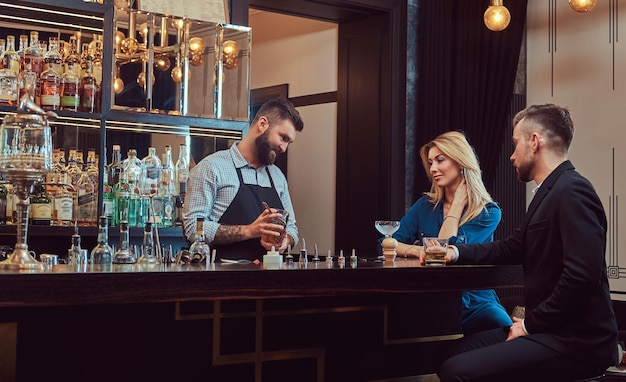 L'elegante barista brutale serve una coppia attraente che trascorre una serata ad un appuntamento.