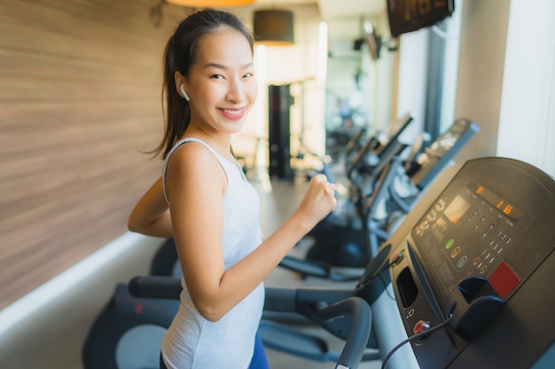 L&#39;esercizio asiatico della donna di bello giovane sport del ritratto e risolve con le attrezzature di forma fisica in palestra