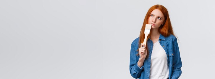 Foto gratuito l'imaging femminile premuroso e creativo della testarossa di che colore sta tenendo il pennello cerca tho