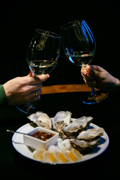 L&#39;immagine del primo piano della mano delle donne e del maschio tiene i vetri di champagne