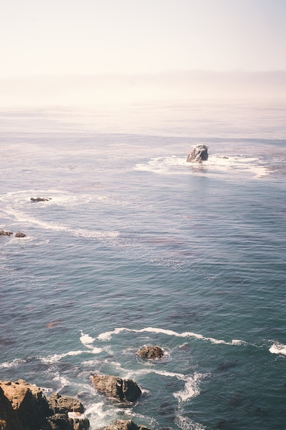 L'immagine verticale di rocce sull'oceano vicino a una scogliera