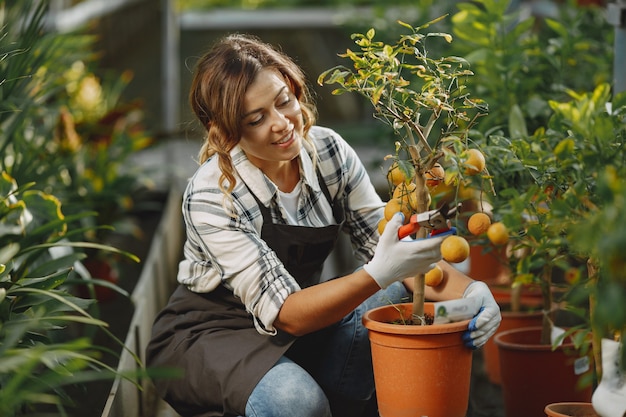 L'operaio si prende cura dei fiori. Ragazza in una camicia bianca. Donna in guanti