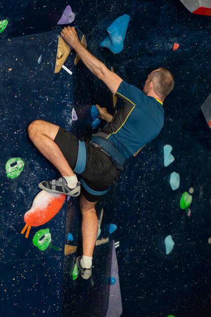 L'uomo arrampicata su roccia al chiuso nell'arena