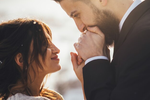 L&#39;uomo barbuto e la sua sposa adorabile posano sulla neve in una foresta magica di inverno