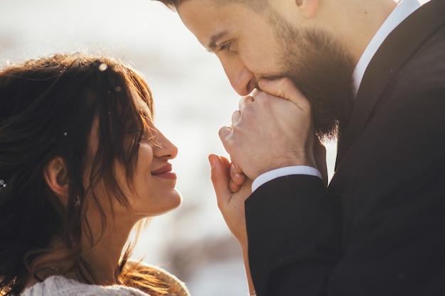 L&#39;uomo barbuto e la sua sposa adorabile posano sulla neve in una foresta magica di inverno