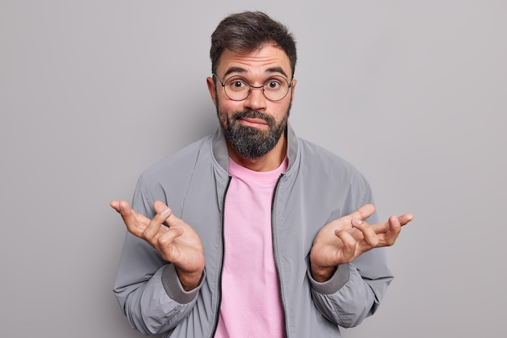 Foto gratuito l'uomo barbuto senza indizi alza le spalle sembra perplesso e inconsapevole dice che non capisco